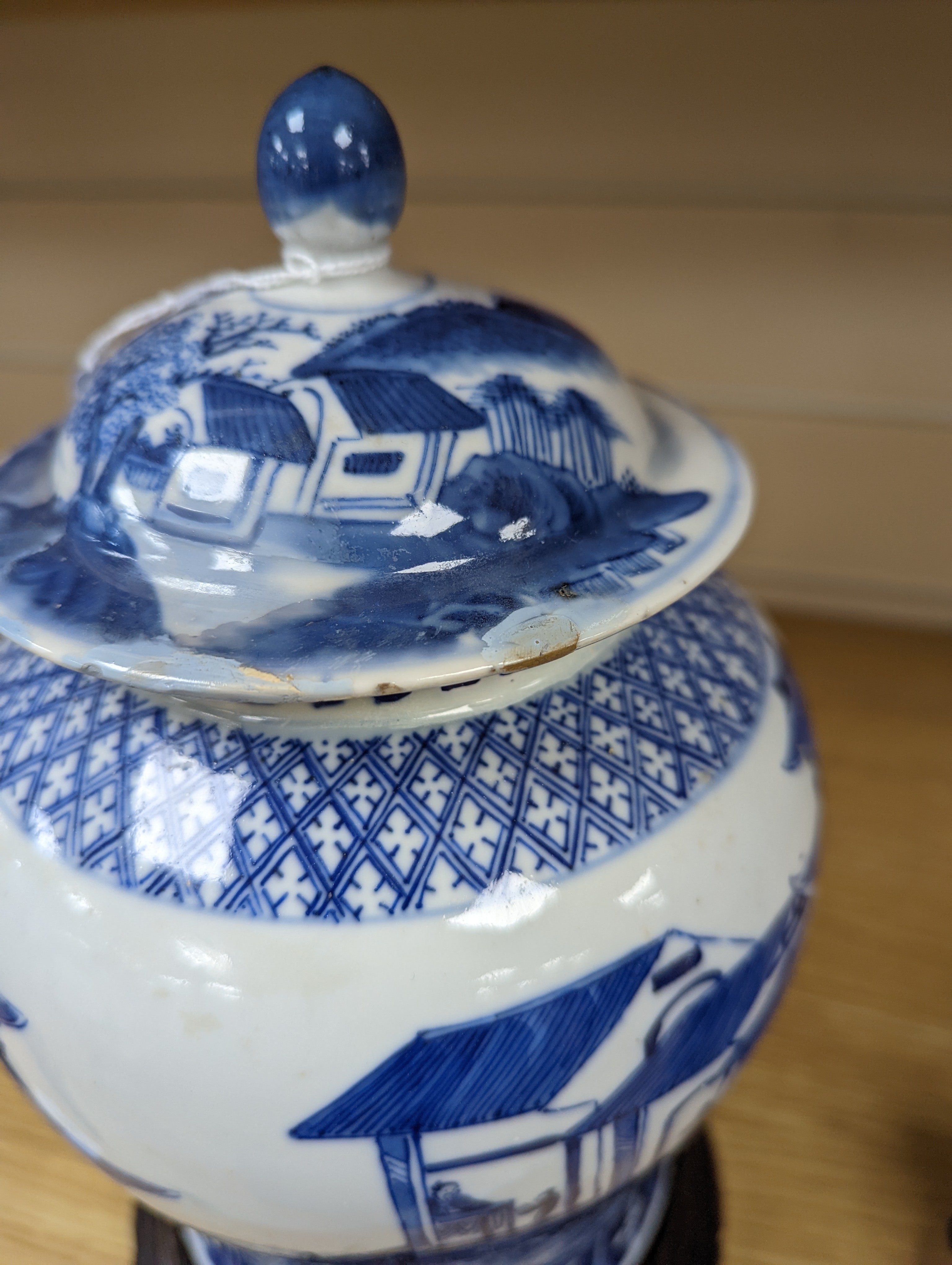 A late 19th / early 20th century Chinese blue and white landscape jar and cover, wood stand 30cm total height